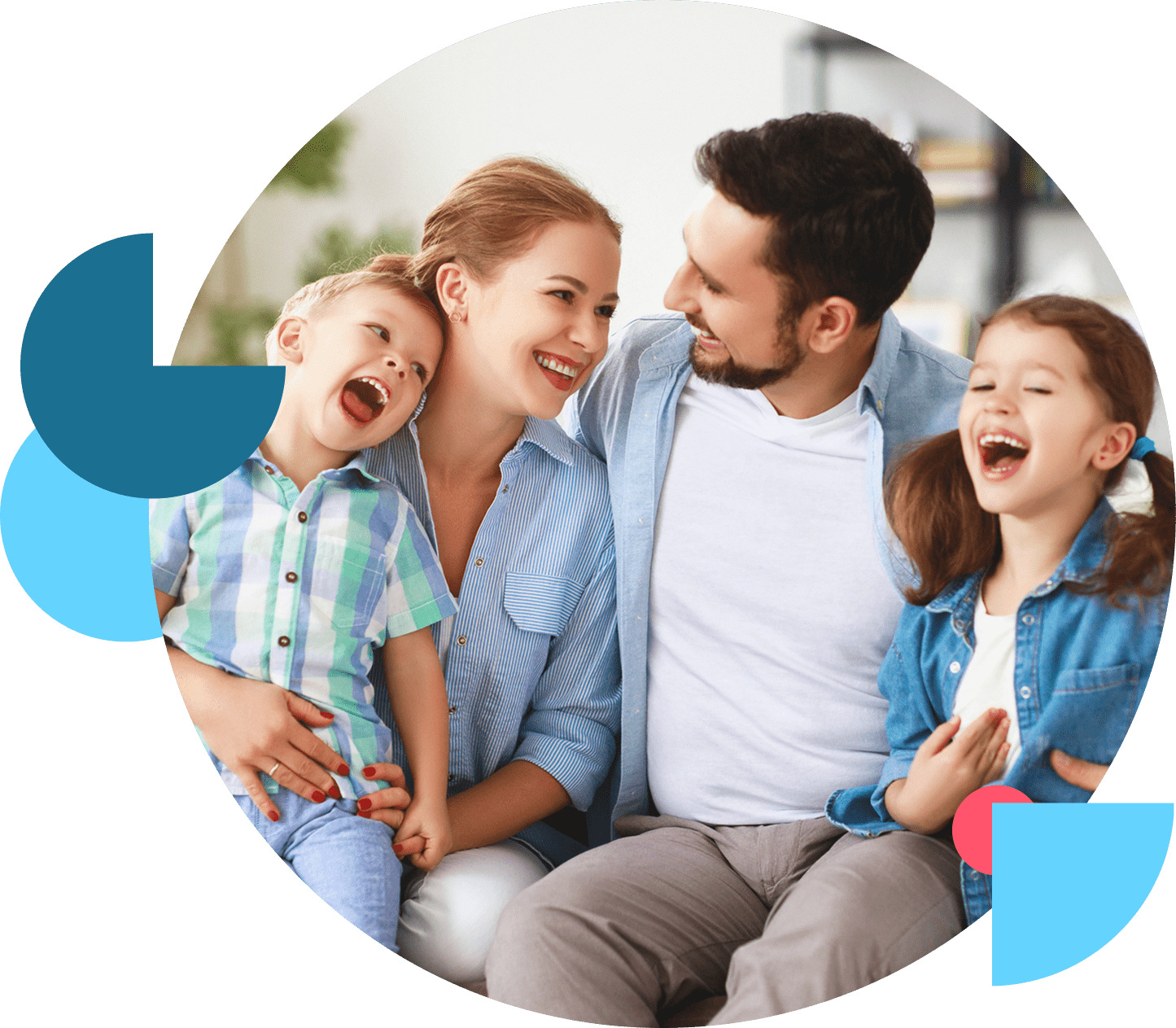 A happy family of four laughing together on a couch.