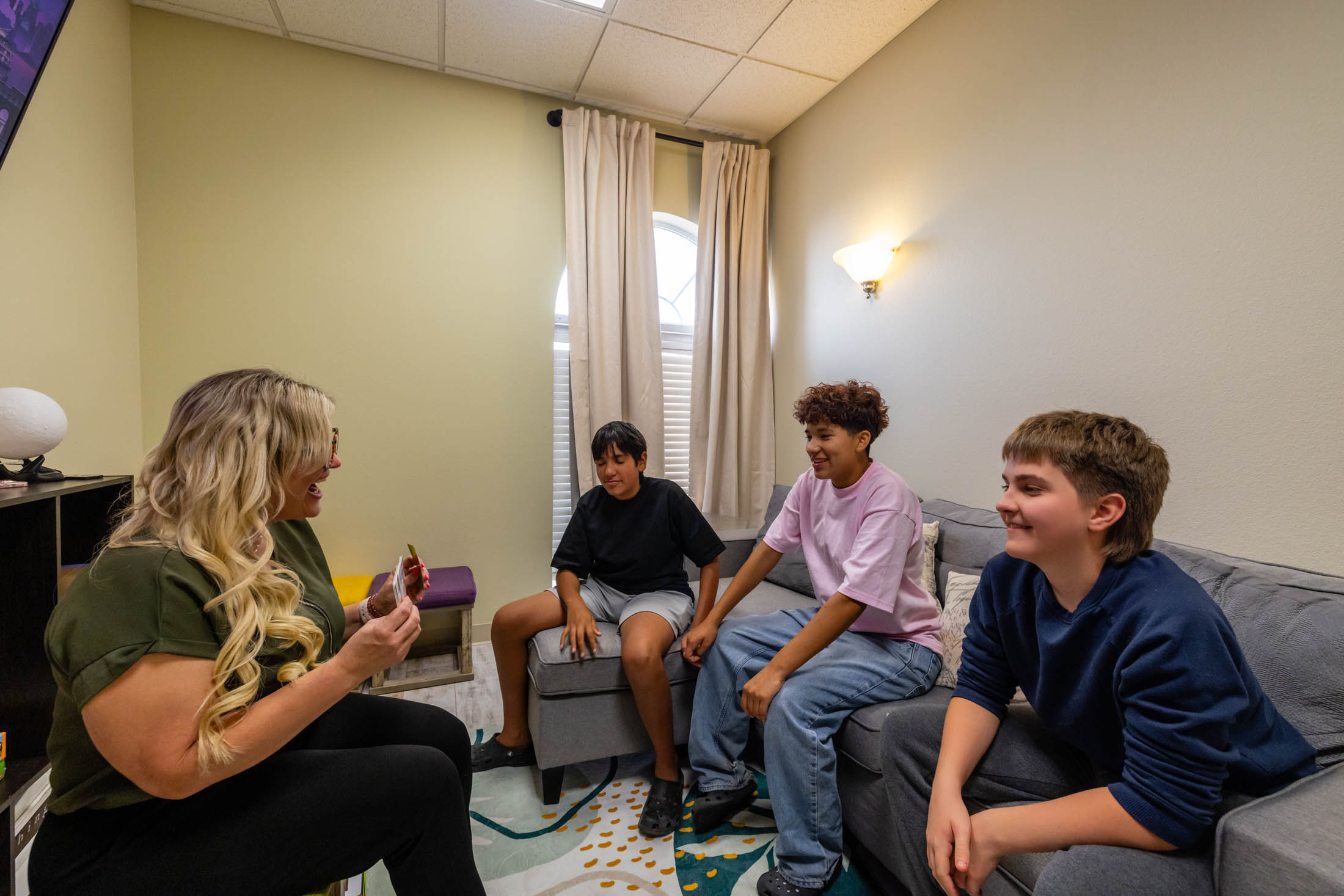Four young people sitting and chatting in a cozy room.